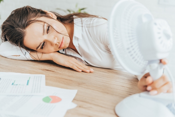 exhaustedbusinesswomanblowingatherselfwithel20221216160537utc.jpg