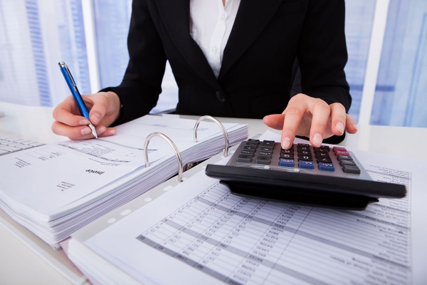 30069004midsectionofbusinesswomancalculatingtaxatofficedesk.jpg